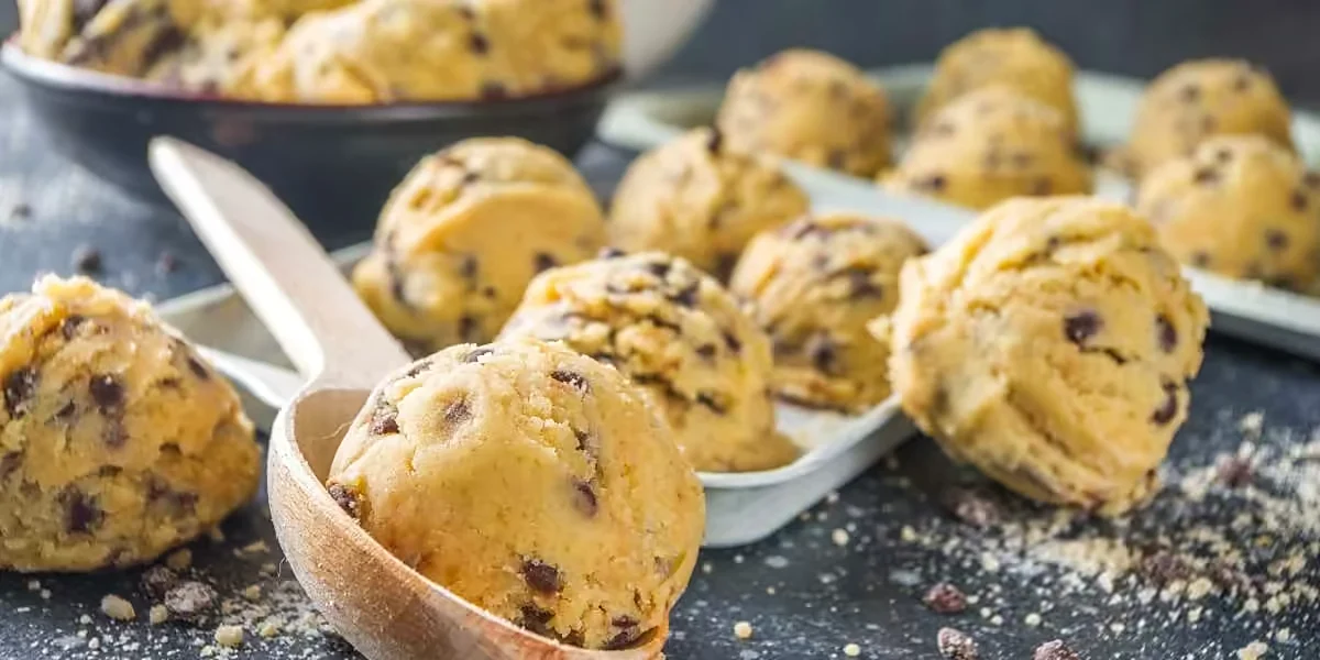 Edibles – Cannabis zum Essen 6 Cookie-Teig mit Schokostückchen auf einem Holzlöffel – Gebäck als klassische Form von Edibles
